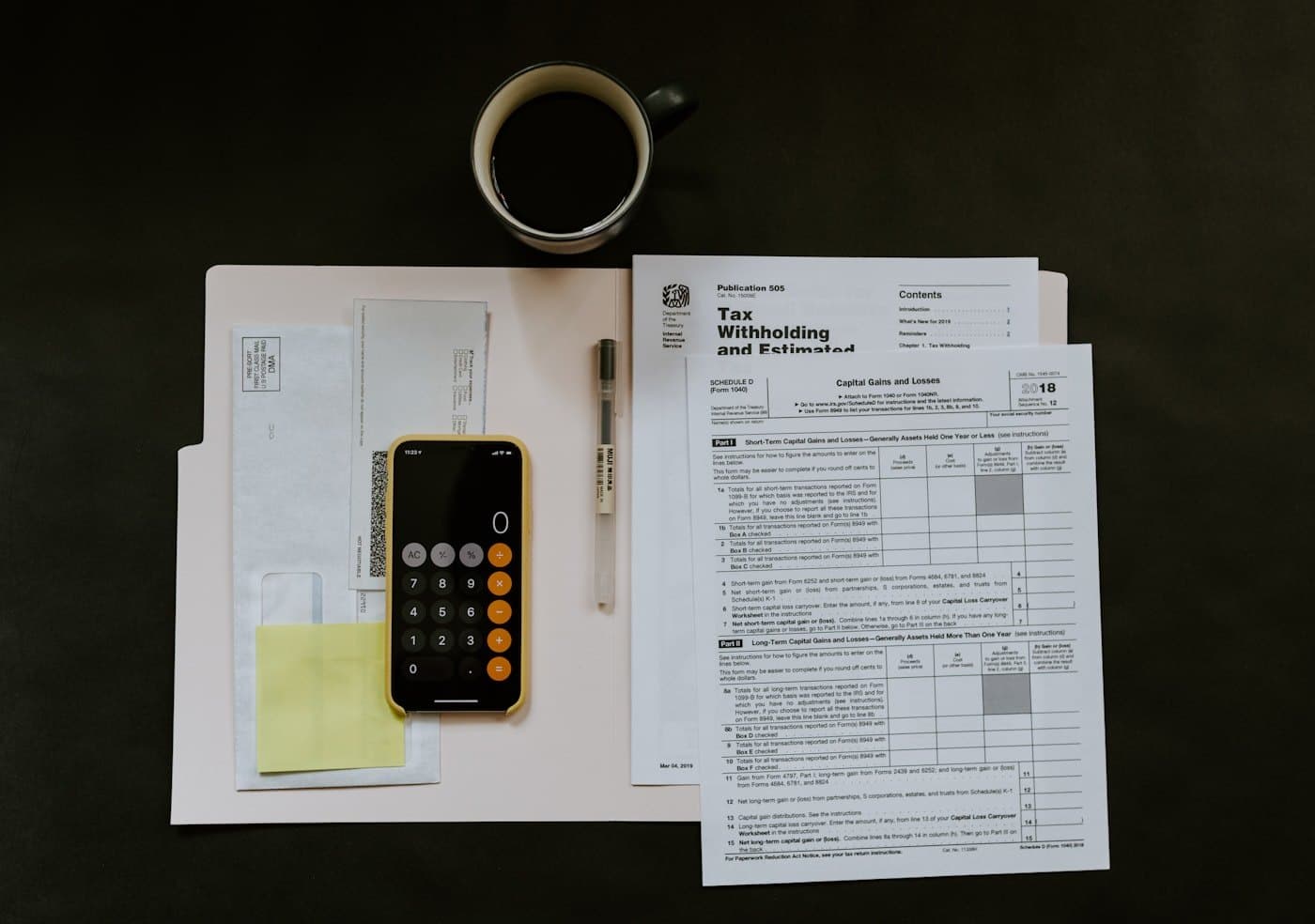 Tax documents, calculator, and pen arranged on a desk